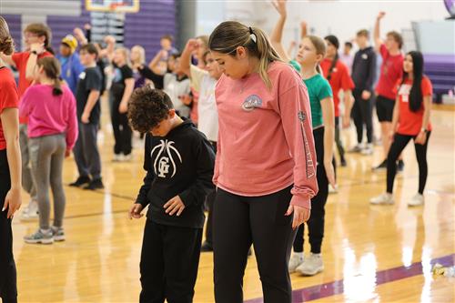 high schooler helping a student with choreography at show choir kids camp
